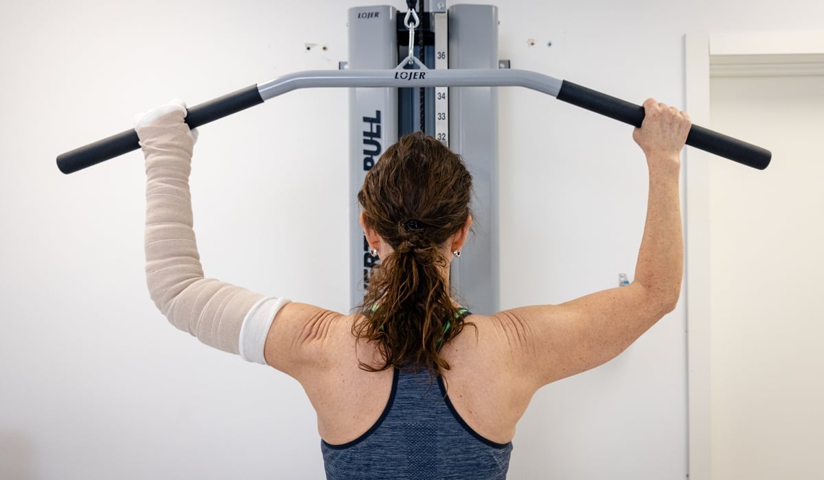 En kvinna som gör en pull up med en stång.