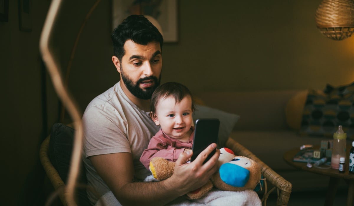 Pappa och dotter tittar på mobil