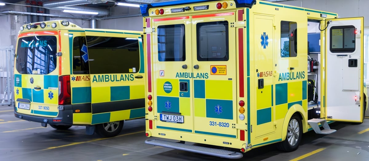 Två ambulanser står parkerade i ett parkeringsgarage.
