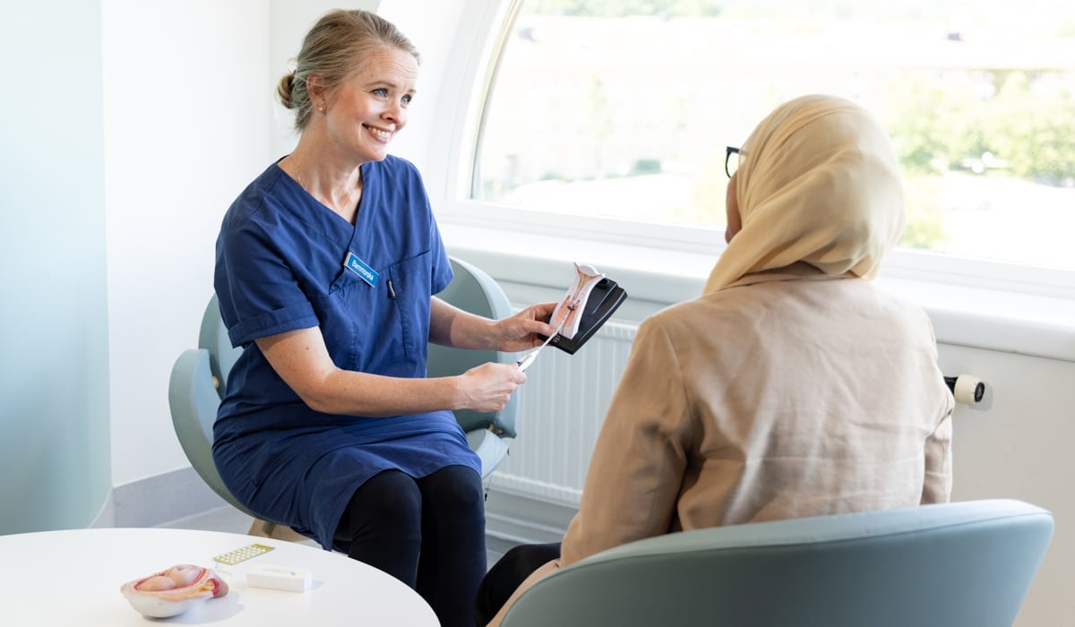 En barnmorska upplyser patient om mödravård.