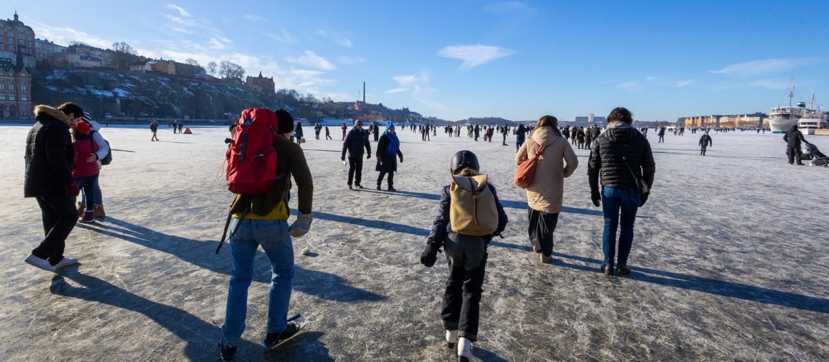 En grupp människor som går över ett snötäckt fält.